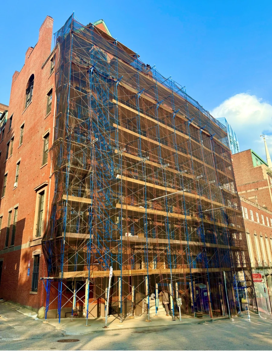Scaffolding covering the exterior of a brick building.